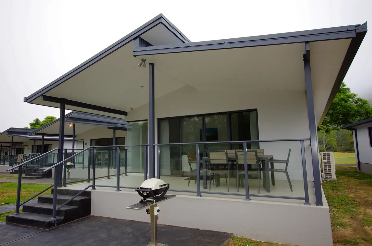 Holiday accommodation at Del Rio: a single-storey building with a covered deck, an outdoor table and a barbecue